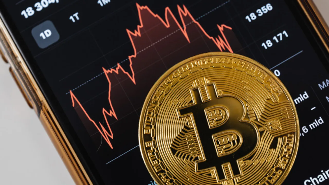 Moneda de Bitcoin sobre una gráfica descendente al comprar Bitcoin en un mercado bajista
