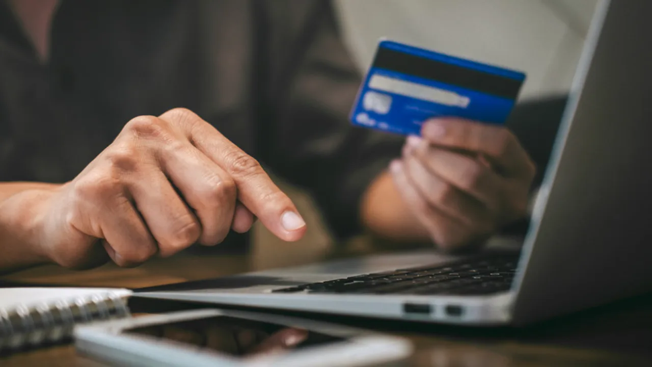 Persona usando una tarjeta y una laptop para un pago en linea, como cobrar a clientes del extranjero