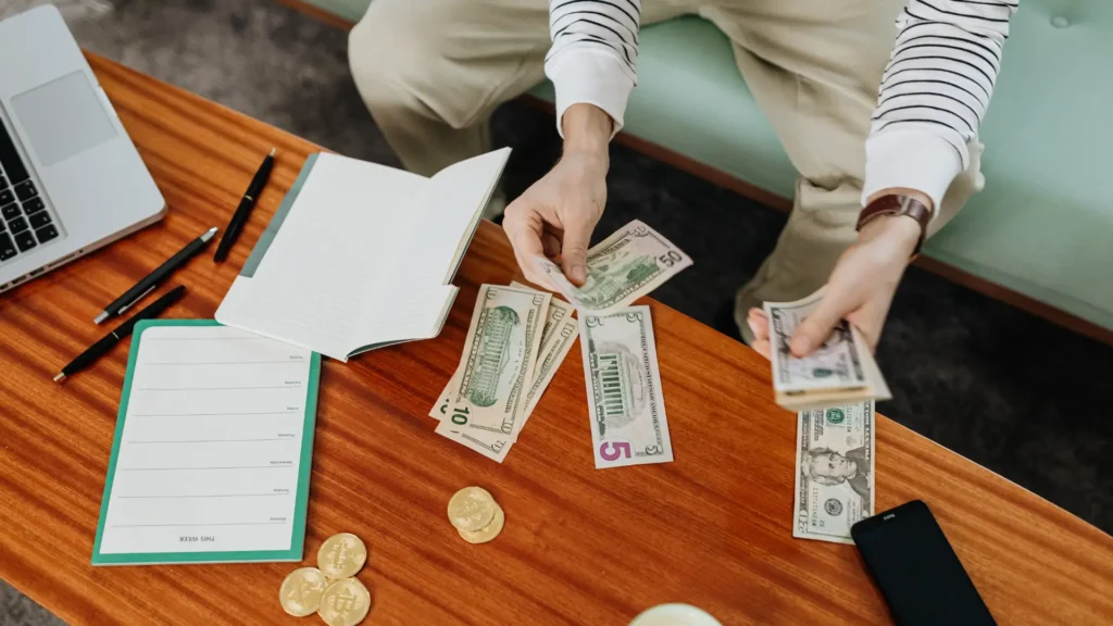 Persona contando dinero y administrando presupuesto para mejorar salud financiera