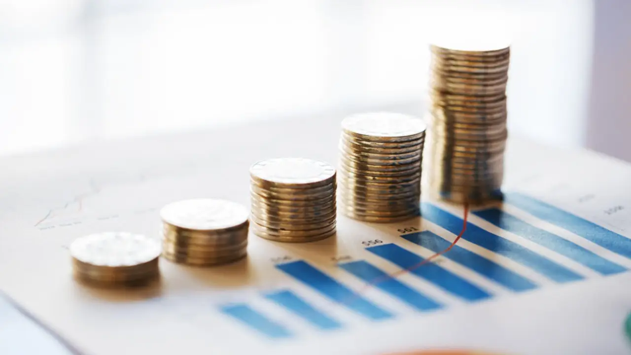 Monedas apiladas sobre graficas: opciones de inversion comparadas en Mexico
