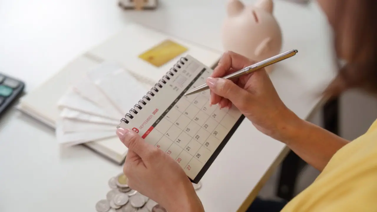 Marcar metas financieras en un calendario con monedas y documentos